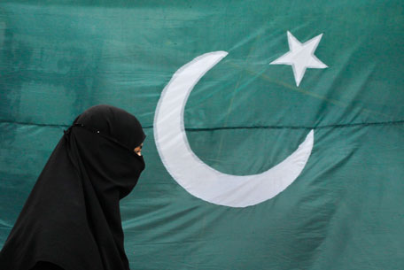 A woman clad in a burqa walks past the national flag of Pakistan, which is being displayed for sale ahead of Pakistan's Independence Day, in Lahore August 13, 2011. Pakistan commemorates its Independence Day on August 14. (REUTERS)