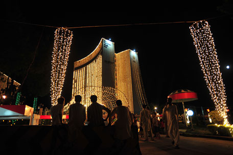Pakistani people walk past buildings decorated with strands of lights in celebration of Independence Day in Islamabad on August 13, 2011. The 64th Independence Day will be observed on August 14 throughout the country. (AFP)