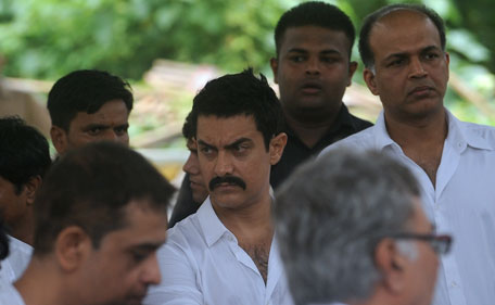 Indian Bollywood actor Aamir Khan (C) and director Ashutosh Gowarikar (R) attend the funeral of the late Bollywood actor Shammi Kapoor in Mumbai on August 15, 2011. Legendary Bollywood heart-throb Shammi Kapoor, whose energetic acting and dancing style heavily influenced modern-day Indian film stars, died on August 14 aged 79.  (AFP)