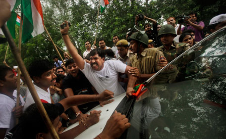 Supporters of Indian rights activist Anna Hazare try to block a police van after he was detained prior to beginning a hunger strike in New Delhi, India, Tuesday, Aug. 16, 2011. The prominent activist who had announced an indefinite hunger strike to demand tougher anti-corruption laws was detained early Tuesday morning, police said. (AP)