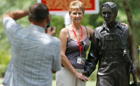 Michael Winwood of South Hampton England gets a photo of his wife, Dianne,  during Elvis Fan Appreciation Day at the Elvis Presley Birthplace Wednesday, Aug 10, 2011  in Tupelo Miss.  (AP)