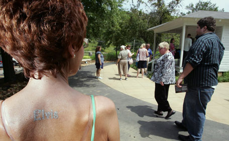 With "Elvis" stamped on her back, Gaynor Gregory, of South Wales, waits her turn to make a tour through the Elvis Presley Birthplace during Elvis Fan Appreciation Day in Tupelo Miss. Wednesday, Aug 10, 2011. (AP)