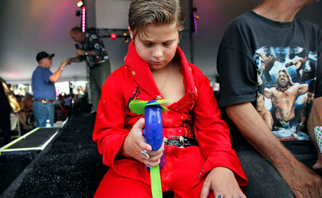 Brandon Bird, 9, tries to keep cool in his self-designed jumpsuit during a series of performances by Elvis tribute artists at the Graceland Entertainment Pavilion in Memphis, Tenn, before a vigil marking the 34th anniversary of the death of Elvis Presley Monday night, Aug. 15, 2011. (AP)
