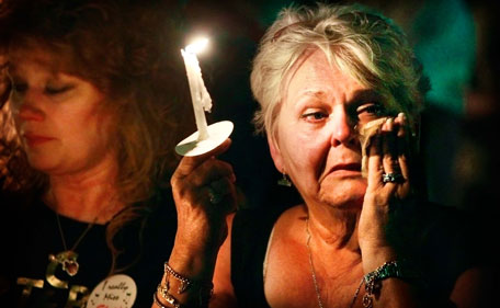 Charlotte Stone of Griffin, Ga., wipes tears from her eyes as the song "Can't Help Falling In Love" is played during a candlelight vigil marking the 34th anniversary of the death of Elvis Presley, Monday, Aug 15, 2011 at Graceland in Memphis, Tenn. (AP)