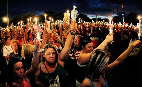 Elvis fans from all over the world gather at the gates of Graceland for a candlelight vigil marking the 34th anniversary of the death of Elvis Presley, Monday, Aug 15, 2011 in Memphis, Tenn. (AP)