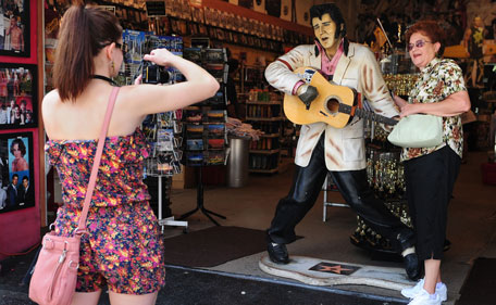 A woman has her photo taken beside a life-sized model of the late Elvis Presley at a tourist gift-shop on the 34th anniversary of his death on August 16, 2011 in Hollywood, California. One of the most popular American singers of the 20th century, Elvis Aaron Presley was widely known by the single name "Elvis" or simply "the King", in reference to being annointed the "King of Rock and Roll." (AFP)