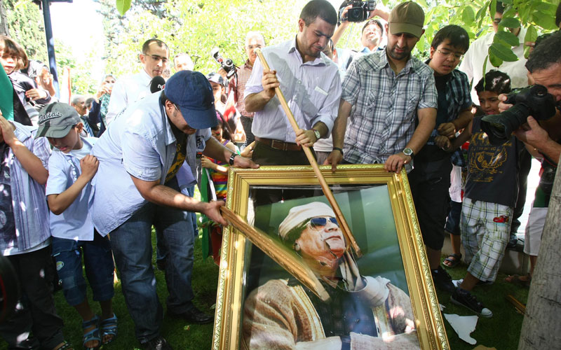 Demonstrators smash a portrait of Moamer Kadhafi during a protest against Kadhafi outside the Libyan embassy in Ankara. Libyan opposition groups hauled down the flag of the Moamer Kadhafi regime at the embassy in the Turkish capital and flew the rebel flag, as fighting rages in Libya today near the compound of embattled of the Libyan leader  and in other parts of Tripoli, a day after jubilant rebels overran the symbolic heart of the capital. (AFP)