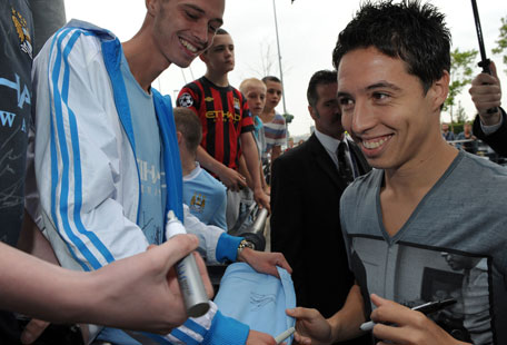 Samir Nasri signs autographs as he is greeted by fans outside Manchester City's Etihad Stadium in north-west England, on Wednesday. (AFP)
