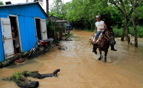 A resident rides a horse through a flooded neighborhood after the passing of Hurricane Irene in Nagua on the northern coast of the Dominican Republic, Tuesday Aug 23, 2011.  Hundreds were displaced by flooding in the Dominican Republic, forced to take refuge in churches, schools or relatives' homes. Electricity also was cut in some areas. (AP)