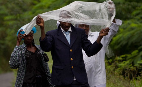 People cover from the rain as they make their way during the passing of Hurricane Irene on a road from Gonaives to Cap Haitian, Haiti, Tuesday, Aug 23, 2011. Irene was still lashing the northern coasts of Haiti and the Dominican Republic, where crews have begun cleaning up debris and the government warned of flooding. (AP)