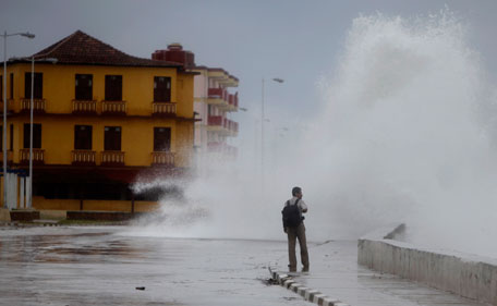 A man walks where a wave sprays the street as the outer bands of Hurricane Irene affect Baracoa, Cuba, Wednesday Aug 24, 2011. (AP)