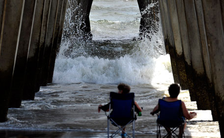 Visitors from Dahlonega, Ga, watch the surf crash into the pylons under the pier on Tybee Island, Ga, Wednesday, Aug 24, 2011, as Hurricane Irene heads towards South Florida. Forecasters are predicting that Irene will strike North Carolina's Outer Banks on Saturday. (AP)
