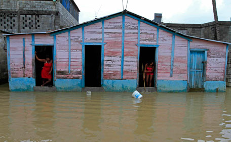 Residents watch the water outside their home in the Moscu neighborhood of Dominican Republic of an overflowed river after the passing of Hurricane Irene on Wednesday, Aug 24, 2010. Flooding, rising rivers and mudslides have prompted the Dominican Republic government to evacuate nearly 38,000 people and more slides were likely in coming days because of days of intense rain from the storm system. (AP)