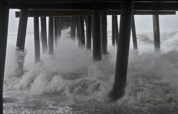 Huge waves pound Nags Head Fishing Pier in Nags Head in the Outer Banks of North Carolina on August 27, 2011 as Hurricane Irene pounded the coast of North Carolina. Hurricane Irene clobbered the US east coast Saturday, killing at least three people and paralyzing air traffic before barreling north on course for a rare direct hit on New York City. (AFP)