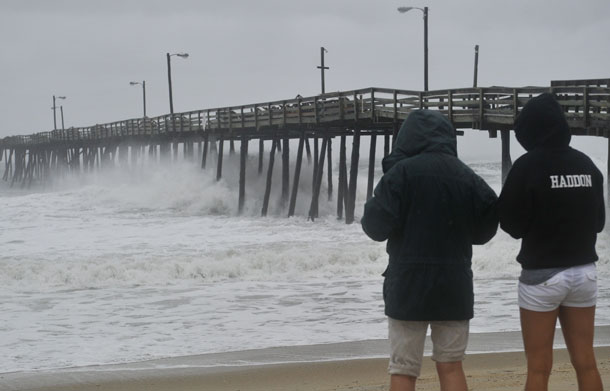 A woman and her daughter watch huge waves pound Nags Head Fishing Pier in Nags Head in the Outer Banks of North Carolina on August 27, 2011 as Hurricane Irene pounded the coast of North Carolina. Hurricane Irene clobbered the US east coast Saturday, killing at least three people and paralyzing air traffic before barreling north on course for a rare direct hit on New York City. (AFP)