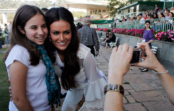 Miss Brazil 2011 Priscila Machado poses for a photo with a child during a visit to the Jockey Club horse race track in Sao Paulo August 27, 2011. Miss Universe contestants are in Sao Paulo for the Miss Universe pageant which will be held on September 12. (REUTERS)