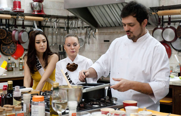 Miss South Korea 2011 Sora Chong (L)  and Miss Kazakhstan 2011 Valeriya Aleinikova (C) watch chef Renato Reinas cook at Atelie Groumand in Sao Paulo, August 27, 2011. The Miss Universe pageant will be held in Sao Paulo on September 12. (REUTERS)