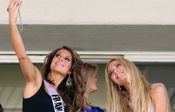 Miss France 2011 Laury Thilleman (L) takes a photograph with Miss Netherlands 2011 Kelly Weekers (R) and Miss Belgium 2011 Justine De Jonckheere as they visit Jockey Club horce race track in Sao Paulo August 27, 2011. The contestants are in Sao Paulo for the 2011 Miss Universe pageant which will be held on September 12. (REUTERS)