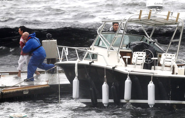 Rescue workers help a woman off a floating dock they feared was going to break loose during Hurricane Irene in New Bedford, Mass. Sunday, Aug 28, 2011. Irene weakened to winds of 60 mph, well below the 74 mph dividing line between a hurricane and tropical storm. The system was still massive and powerful, forming a figure six that covered the Northeast. It was moving twice as fast as the day before. (AP)