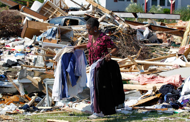 Janie Gibbs helps clean up a friend's destroyed home Sunday, Aug 28, 2011 after it was hit by Hurricane Irene Saturday in Columbia, NC. The storm killed at least 14 people and left 4 million homes and businesses without power. It unloaded more than a foot of water on North Carolina and spun off tornadoes in Virginia, Maryland and Delaware. (AP)