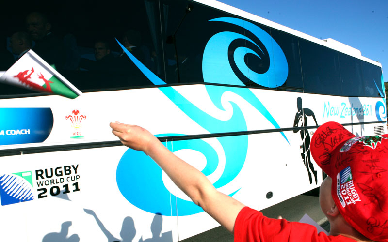 Welsh rugby team supporter waves the national flag as the bus leaves after their arrival in Wellington, New Zealand. Wales will kick off their Rugby World Cup 2011 campaign against South Africa on Sept. 11, 2011. (AP)