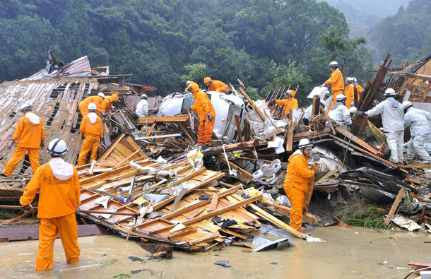 Firefighters and rescue workers search through the debris of houses collapsed by a landslide in Tanabe, Wakayama prefecture, western Japan Sunday, Sept. 4, 2011. Powerful Typhoon Talas left a trail of heavy rainfall and mudslides as it moved northward past Japan on Sunday. (AP)