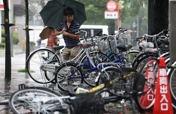 A man holds an umbrella as he walks past a rack wiith fallen bicycles in Himeji, Japan. The Japan Meteorological Agency has issued heavy rain and wind warnings. 30,000 people have been advised to evacuate areas across of Western Japan as the typhoon sweeps in from the Pacific. (GETTY/GALLO)