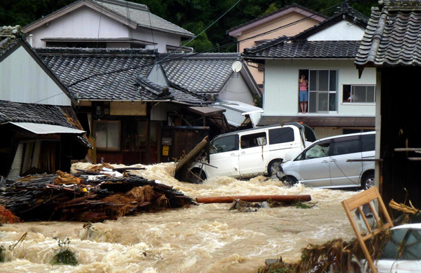Overflowing water from a river floods a residential area in Nachikatsuura, central Japan. The center of the season's 12th typhoon was moving slowly north across the Sea of Japan, the Japan Meteorological Agency said. (AP)