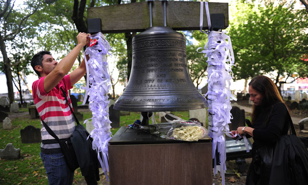 People tie "Ribbon of Rememberance" on "The Bell of Hope", a bell offered by the city of London and which rings once a year on September 11 to remember victims from the 9/11 World Trade Center attacks, at St Paul's Chapel near Ground Zero, in New York, September 8, 2011. New York is getting ready to commemorate the 10th anniversary of the 9/11 attacks on the World Trade Center towers. (AFP)