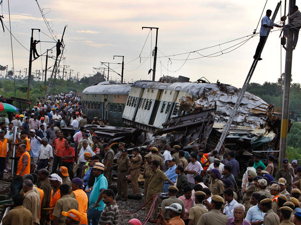 Rescue workers and others crowd next to the derailed compartments of a passenger train after two trains collided near Arakkonam, southwest of Chennai, India, Wednesday, Sept. 14, 2011. The passenger train traveling through southern India collided with another train stopped at a signal on Tuesday, killing eight people and injuring dozens more, a government official said. (AP)