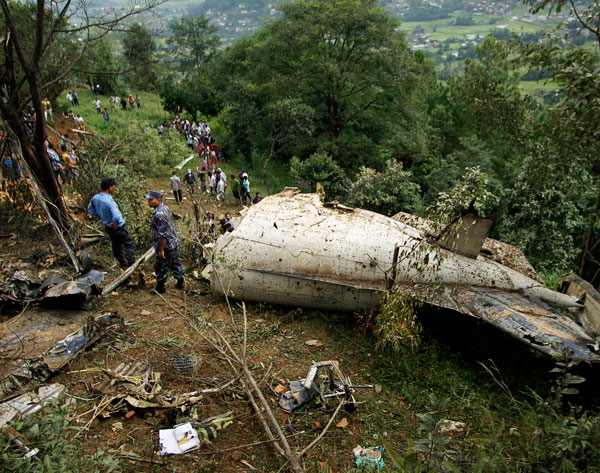 Nepalese rescue workers and civilians gather at the wreckage of a Beechcraft  1900D operated by Buddha Air  after it crashed in the mountains outside Bisankunarayan village, just south of Katmandu, Nepal, early Sunday, Sept. 25, 2011. The plane carrying tourists to view Mount Everest crashed while attempting to land in dense fog in Nepal on Sunday, killing all 19 people on board, officials said. (AP)