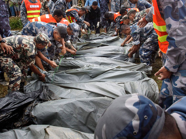 Nepalese rescue workers arrange body bags after they were pulled from the wreckage of a Beechcraft  1900D operated by Buddha Air  after it crashed in the mountains outside Bisankunarayan village, just south of Katmandu, Nepal, early Sunday, Sept. 25, 2011. The plane carrying tourists to view Mount Everest crashed while attempting to land in dense fog in Nepal on Sunday, killing all 19 people on board, officials said. (AP)