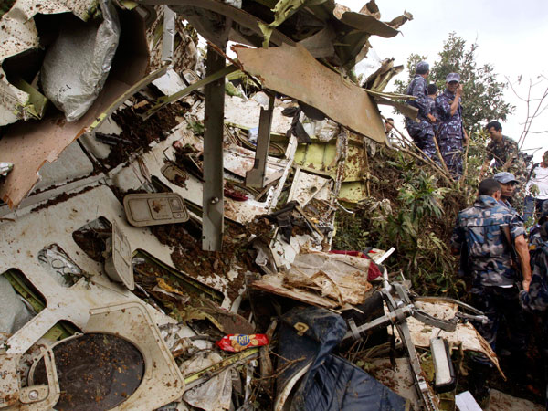 Nepalese rescue workers inspect the wreckage of a Beechcraft  1900D operated by Buddha Air  after it crashed in the mountains outside Bisankunarayan village, just south of Katmandu, Nepal, early Sunday, Sept. 25, 2011. The plane carrying tourists to view Mount Everest crashed while attempting to land in dense fog in Nepal on Sunday, killing all 19 people on board, officials said. (AP)