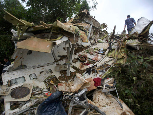 Nepalese police personnel are seen at the crash site of Buddha Air plane in Lalitpur September 25, 2011. A small plane carrying foreign tourists to view Mount Everest crashed in bad weather near Nepal's capital Kathmandu on Sunday, killing all 19 people on board, officials said.   (REUTERS)