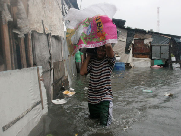 A resident living near the sea front carries his belongings as he evacuates from floodwaters brought by Typhoon Nesat, locally known as Pedring, in Tondo city, metro Manila September 27, 2011. (REUTERS)