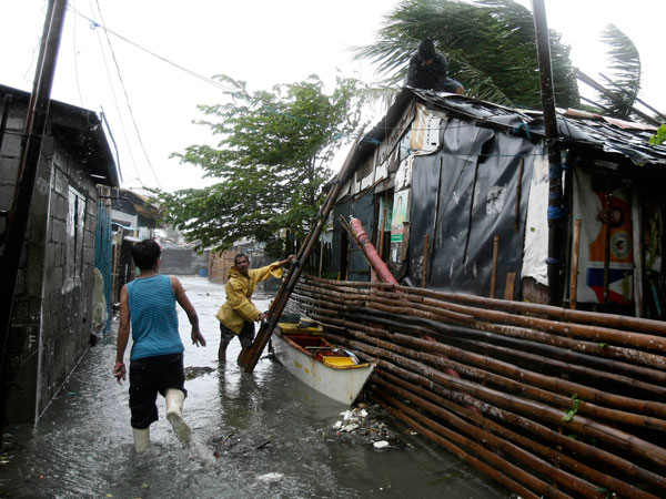 Residents reinforce their houses at the height of typhoon Nesat Tuesday Sept. 27, 2011 in Manila, Philippines. Typhoon Nesat slammed the northeastern Philippines on Tuesday. (AP)