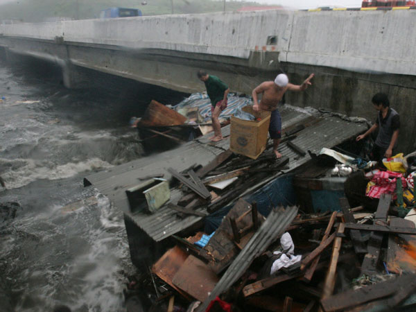 Residents living near the sea front evacuate their shanty after heavy winds and rains brought by Typhoon Nesat, locally known as Pedring, hit Navotas city, north of Manila September 27, 2011. (REUTERS)