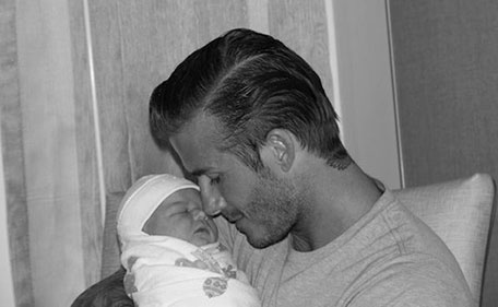 In this photo made available on the Internet from Victoria Beckham on Sunday July 17, 2011, showing British soccer player David Beckham holding his daughter Harper Seven Beckham. The black and white photo was posted on Victoria Beckham's Twitter page Sunday. (AP Photo/Victoria Beckham/Twitter)