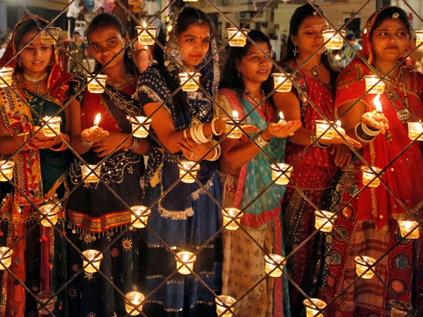 Hindu devotees pose as they hold oil lamps before performing prayers during a ritual known as Aarti at the Navratri festival in the western Indian city of Ahmedabad October 4, 2011. (REUTERS)