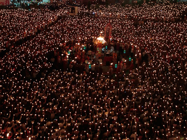 Indian devotees hold earthen lamps as they take part in the Maha Aarti ritual at Hindu deity Umiya Mata temple on the eighth night of Navratri or nine nights festival in Surat, Gujarat state, India, Tuesday, Oct. 4, 2011. (AP)