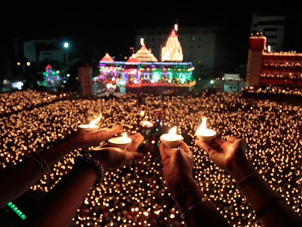 Indian devotees holds earthen lamps and take part in Maha Aarti ritual at Hindu deity Umiya Mata temple on the eighth night of Navratri or nine nights festival in Surat, Gujarat state, India, Tuesday, Oct. 4, 2011. (AP)