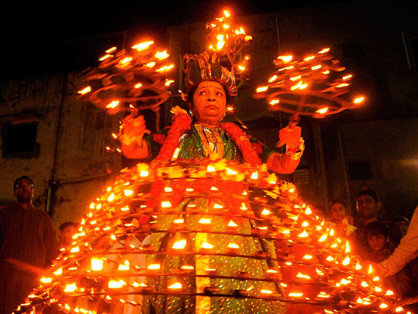 In this picture taken Saturday, Oct. 1, 2011, Indian woman Ushaben Dave, 64, wears dozens of oil lamps during celebrations for the festival of Navratri in Ahmedabad, in the state of Gujarat. The festival, known as Nine Nights, is one of the most important in the Hindu calendar. (AP)