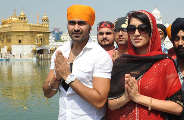Arya Babbar (L) and Jenny Ghotra (C) pay their respects at the world famous Sikh Shrine, the Golden temple, in Amritsar. The actors visited the city as part of a promotional tour for the forthcoming film ‘Yaar Anmulle’ directed by Anurag and produced by Kapil Batra. (AFP)