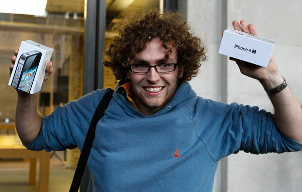 Matthew Kelly from Swansea reacts as he emerges from the Apple store after purchasing two new iPhone 4S handsets, in Covent Garden, London October 14, 2011. Apple Inc's new iPhone went on sale in stores across the globe on Friday, with fans snapping up the final gadget unveiled during Steve Jobs' lifetime, many buying the phone as a tribute to the former Apple boss. (REUTERS)
