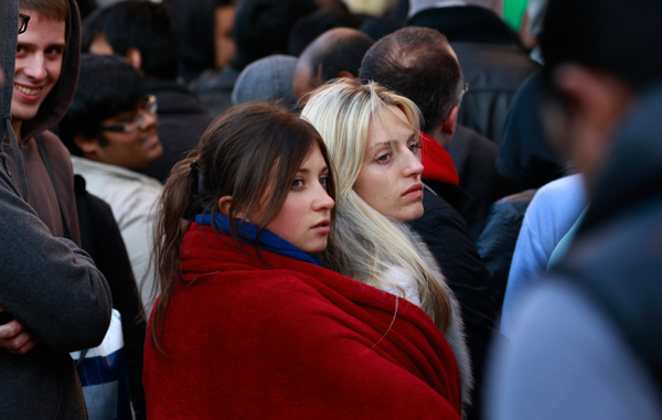 Aliona Ione (L) and her friend Maria Morales from Belarus share a blanket as they queue to buy the new Apple iPhone 4S, in Covent Garden, London. (REUTERS)