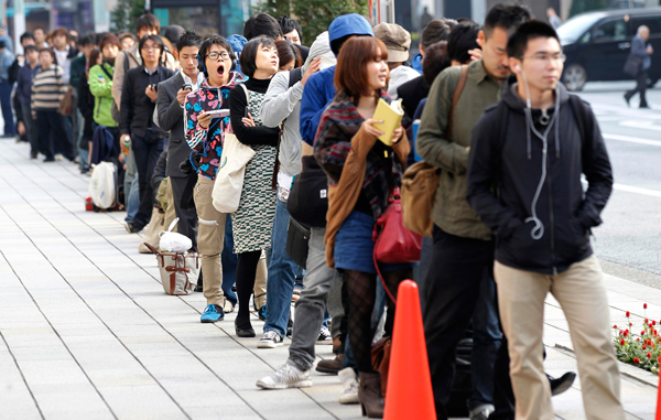 Customers queue to buy iPhone 4S outside an Apple store in Tokyo October 14, 2011.  Apple Inc's latest iPhone went on sale in stores across the globe on Friday, with fans snapping up the final gadget unveiled during Steve Jobs' lifetime, many buying the phone as a tribute to the former Apple boss.  Hundreds of fans queued around city blocks in Tokyo to be the first to get their hands on the iPhone 4S, which looks similar to the previous iPhone 4 but has a better camera, faster processor and well-received voice activated software. (REUTERS)