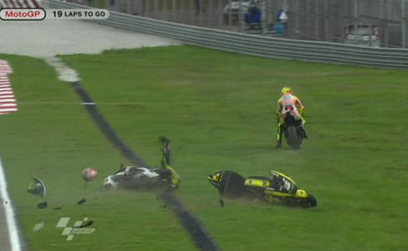 In this image made from video provided by Dorna Sports S.L., the helmet of Italy's Marco Simoncelli, red object at left, is seen after he collided with USA's Colin Edwards, center, and Italy's Valentino Rossi, right, on turn 11 of the Malaysian MotoGP Grand Prix in Sepang, Malaysia, Sunday, Oct. 23, 2011. Italian rider Marco Simoncelli died of chest, head and neck injuries Sunday after a crash at the Malaysian MotoGP motorcycle race, organizers said. He was 24. (AP)