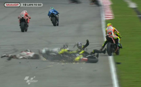 In this image made from video provided by Dorna Sports S.L., Italy's Marco Simoncelli, front left, slides across the track after colliding with USA's Colin Edwards, front center, and Italy's Valentino Rossi, right, on turn 11 of the Malaysian MotoGP Grand Prix in Sepang, Malaysia, Sunday, Oct. 23, 2011. Italian rider Marco Simoncelli died of chest, head and neck injuries Sunday after a crash at the Malaysian MotoGP motorcycle race, organizers said. He was 24. (AP)