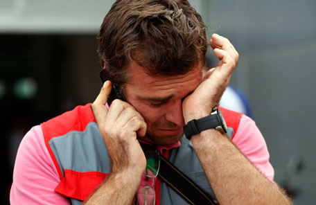 A journalist cries as he talks on his mobile phone after MotoGP rider Marco Simoncelli of Italy died in the crash at the Malaysian MotoGP Grand Prix in Sepang, Malaysia, Sunday, Oct. 23, 2011. A Malaysian MotoGP official says Simoncelli has died after an accident at the race. Norlina Ayob, press officer with the Sepang circuit, says Simoncelli, 24, died as a result of his injuries. (AP)