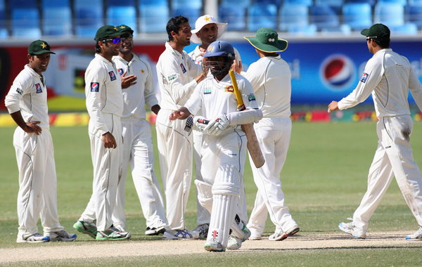 Pakistan's players celebrate the wicket of Sri Lanka's Kaushal Silva during the fourth day of their second cricket test match in Dubai October 29, 2011. (REUTERS)